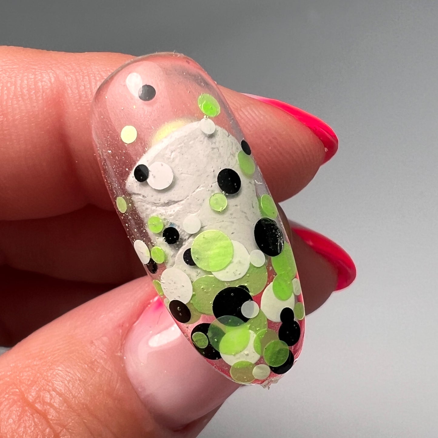 Hand holding decorted nail art tip. 