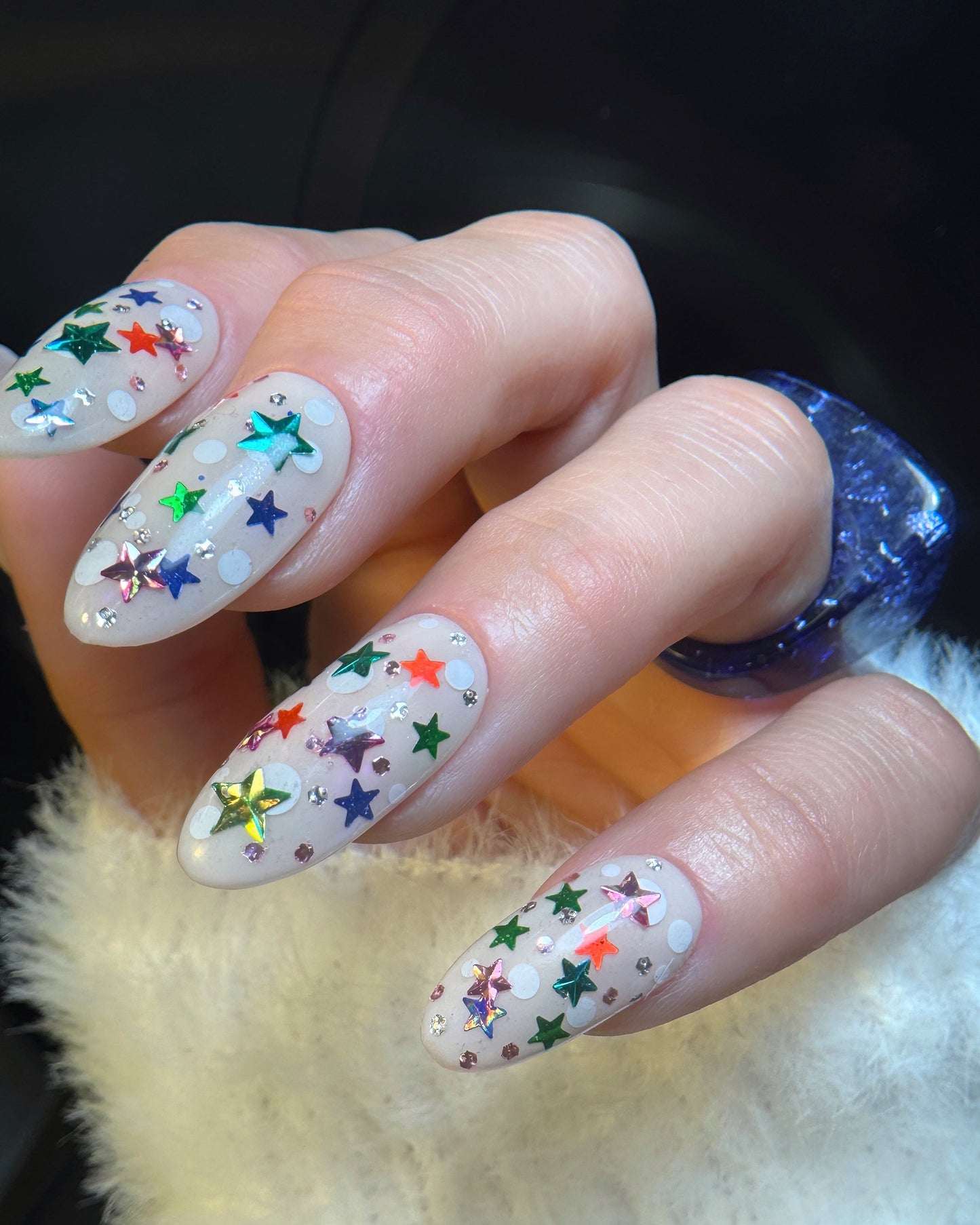 Nails with colorful star designs on a neutral background