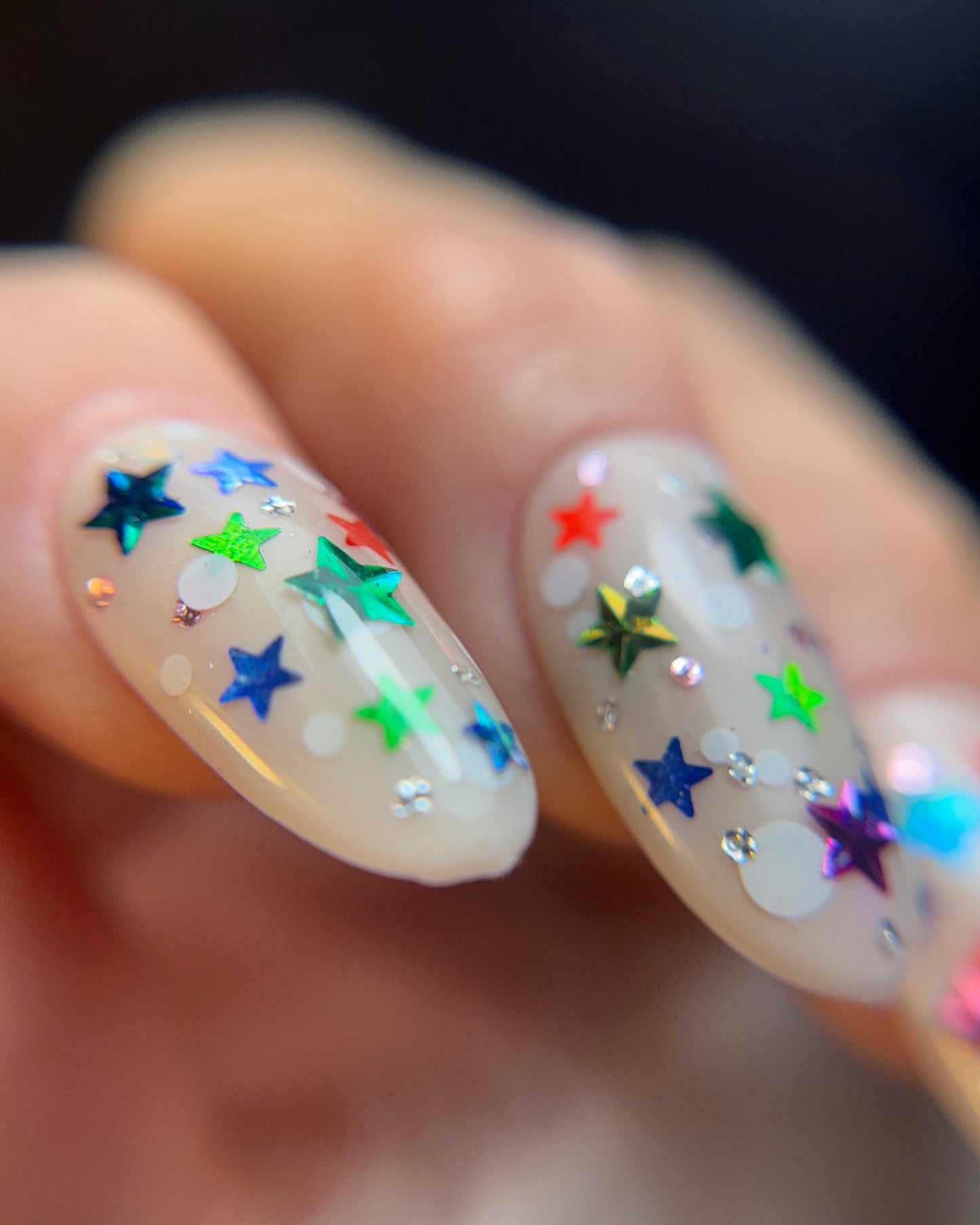 Nails with colorful star decorations on a blurred background