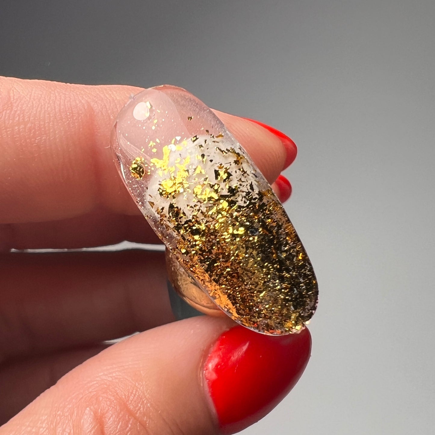 Hand holding decorated nail tip. 