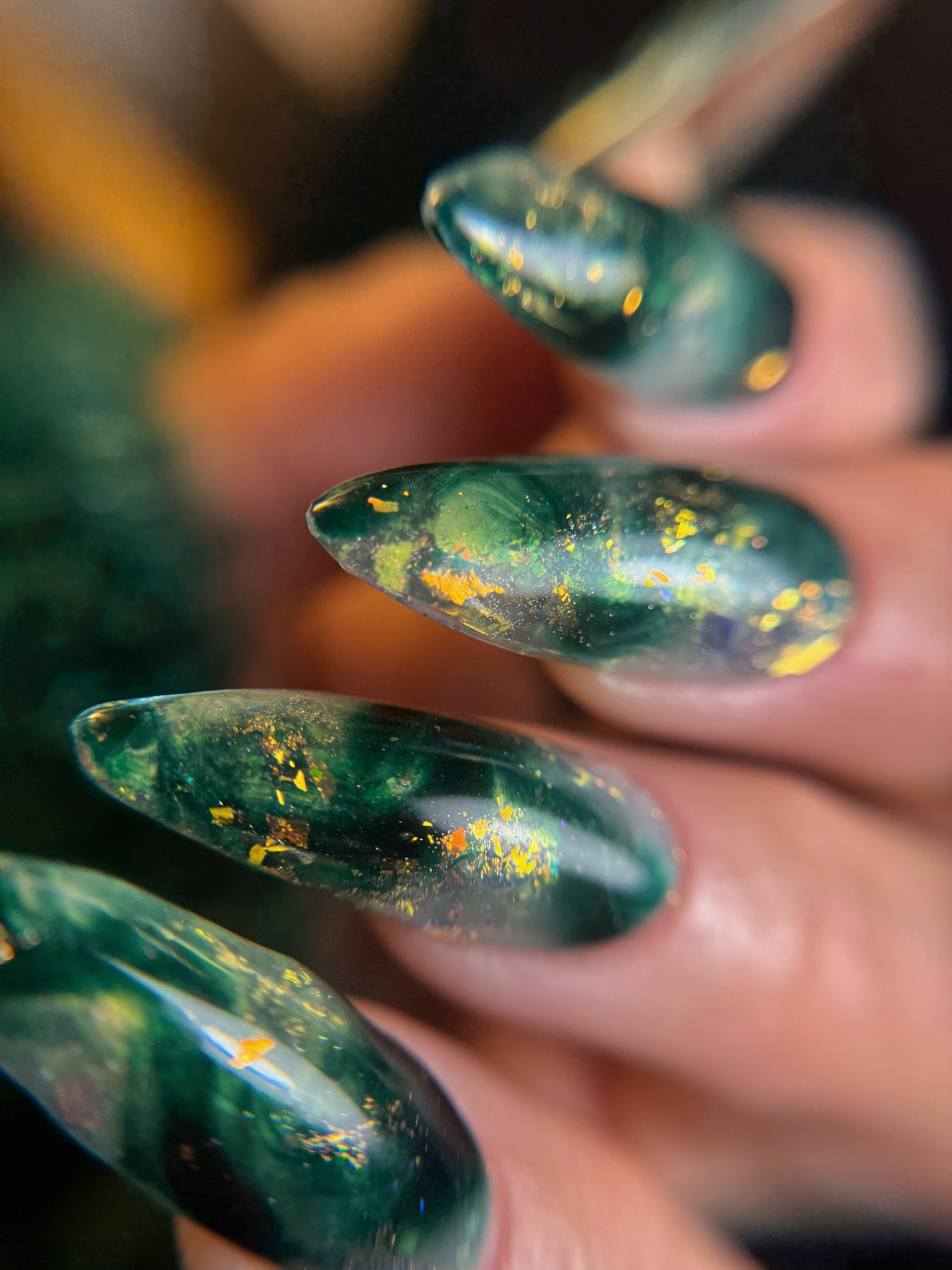 Close-up of green nail design on a blurred background
