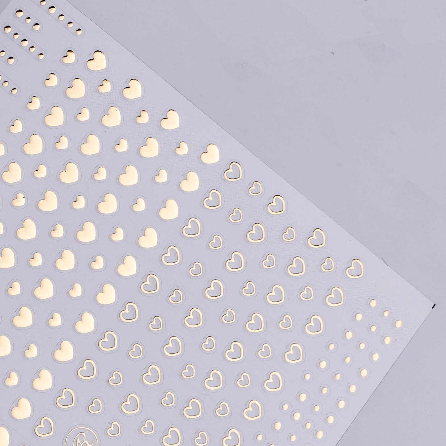 Pattern of gold hearts on a light purple background