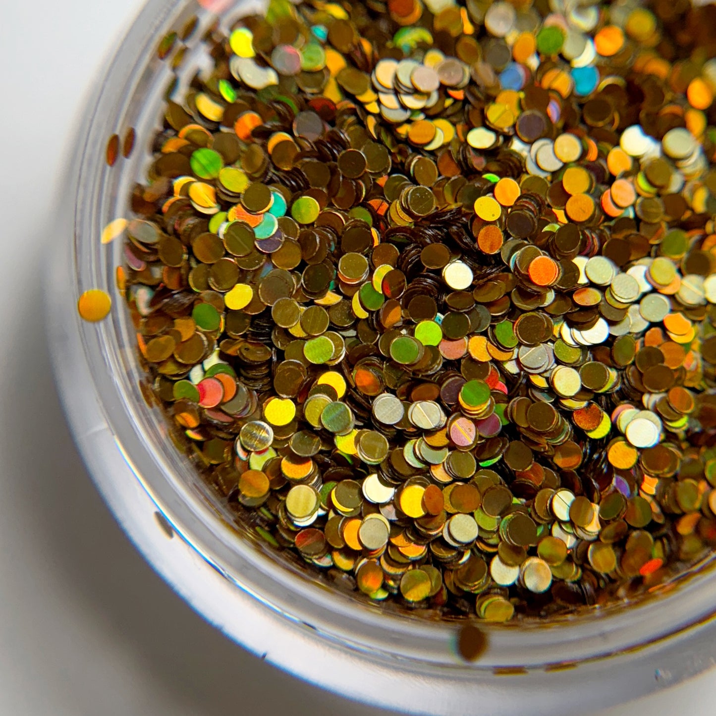 Close up of glitter in transparent jar on white background