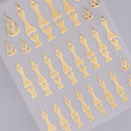 Sheet of gold bone and claw-shaped stickers on a gray background