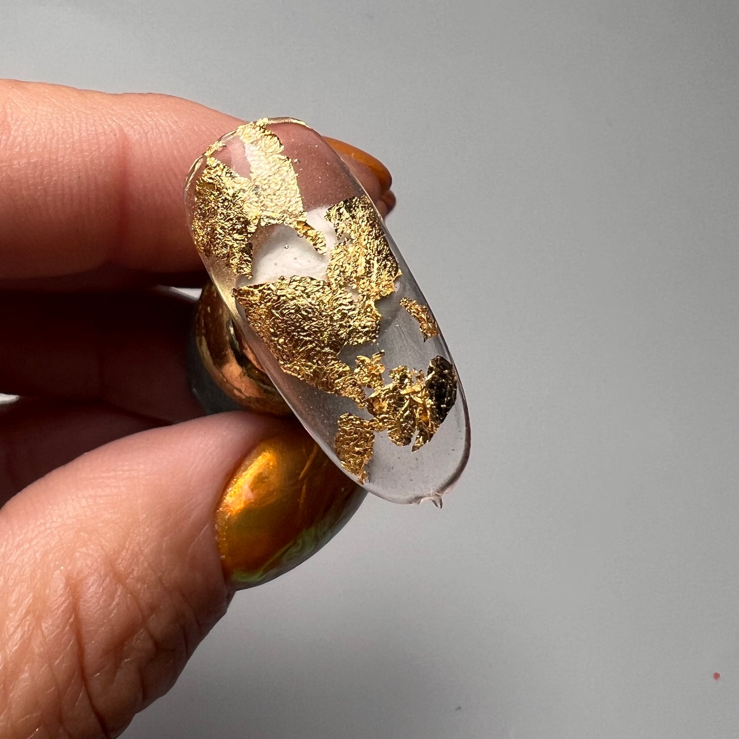 Hand holding decorated nail tip.