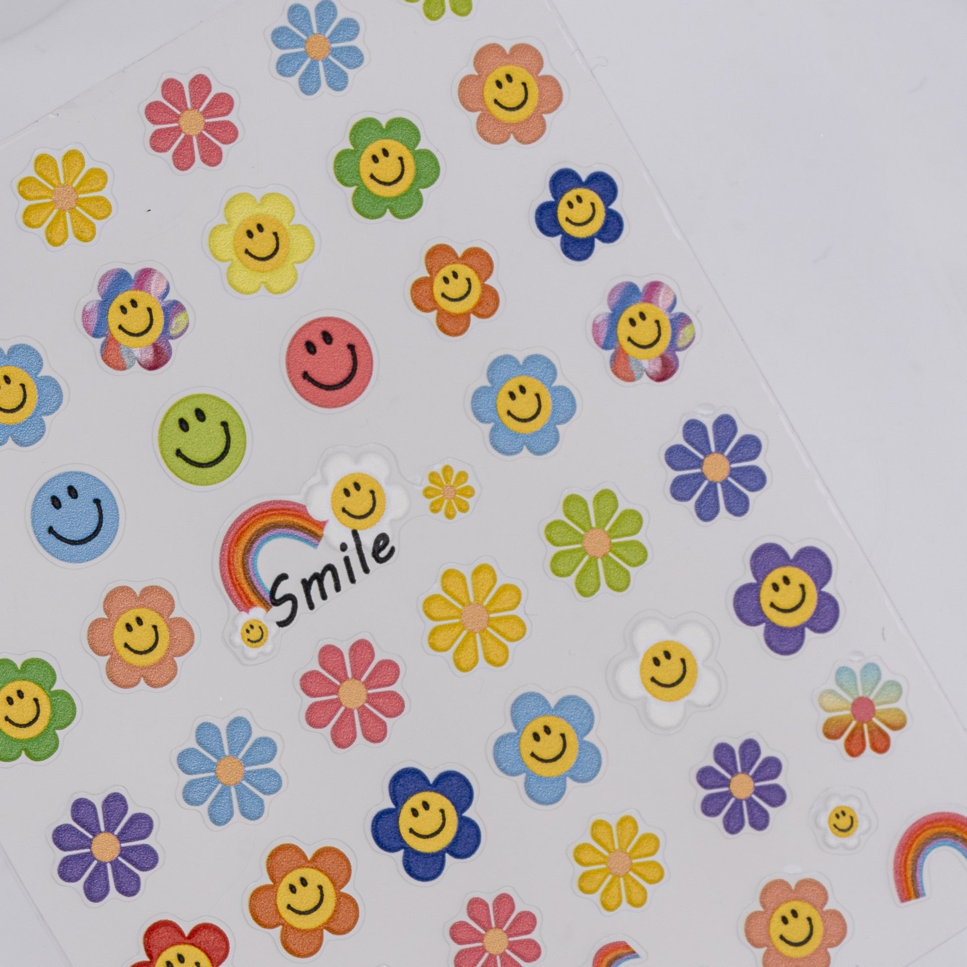 Colorful smiley face and flower stickers on a white background