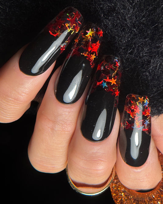 Black nail polish with colorful star designs on a black background