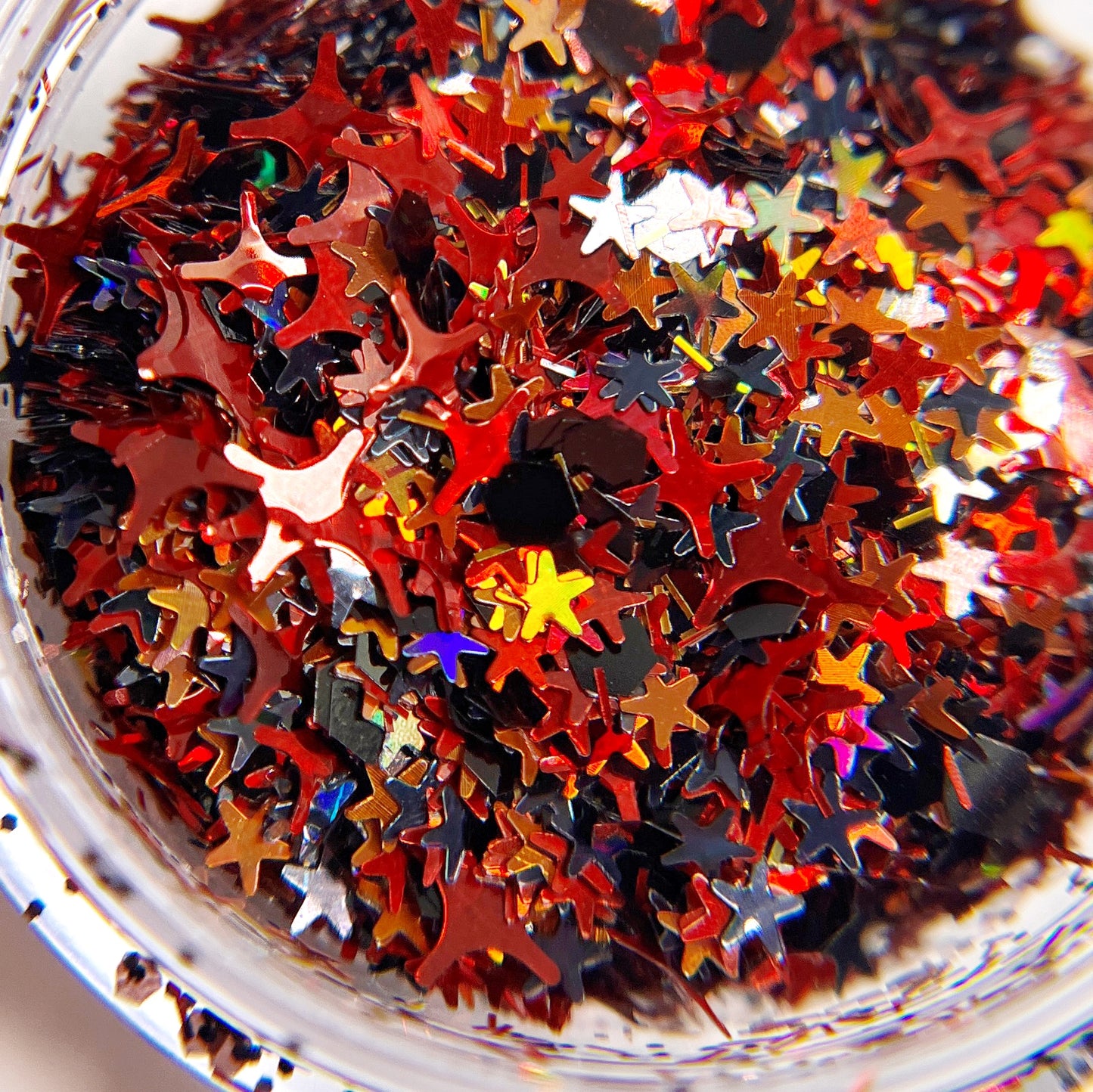 A close-up image of multicolored star-shaped glitter, intended for nail art.