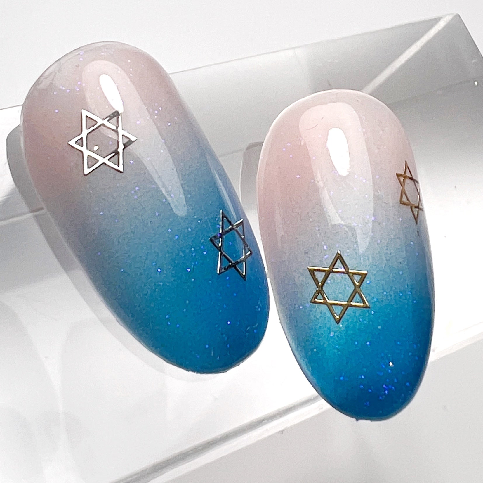 Nail art tips with blue ombre and star detail. 