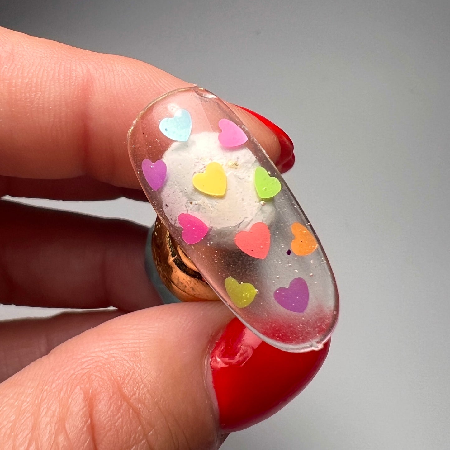 Still of hand holding decorated nail tip. 