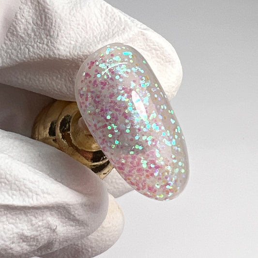 Hand holding decorated nail tip. 