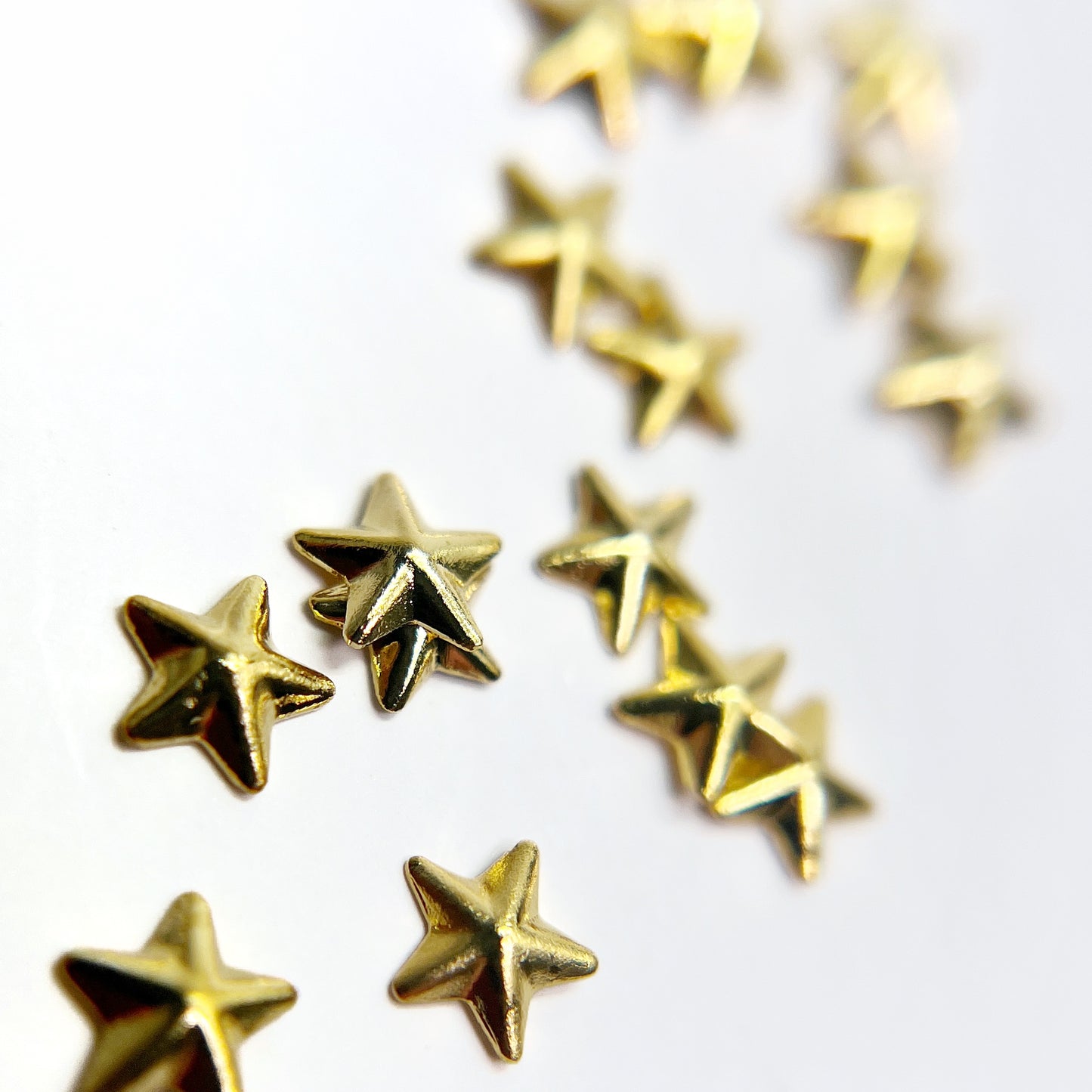Gold star charms scattered on white background.