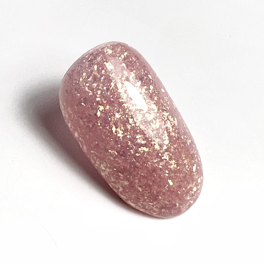 Nail tip with pink and gold glitter on white background.