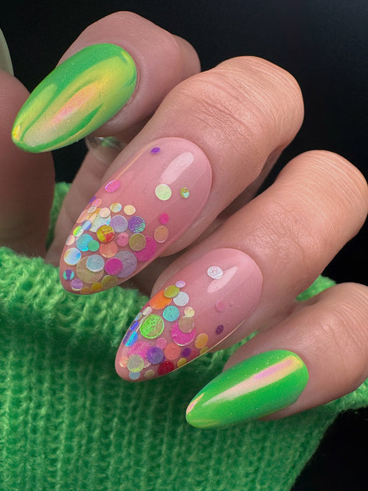 Nails with colorful designs and a green sweater background