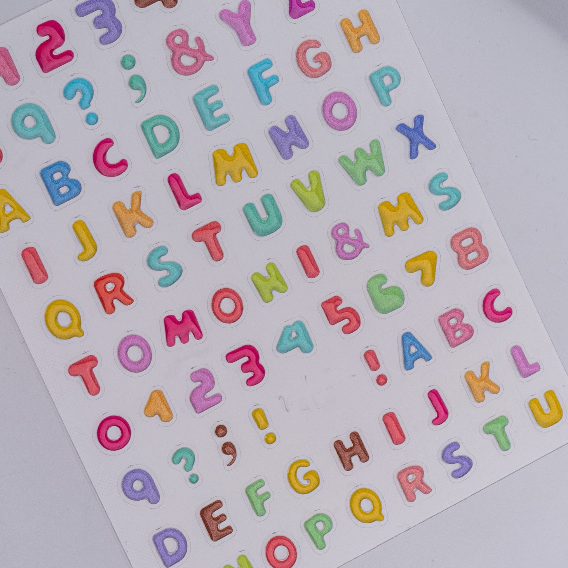 Sheet of colorful alphabet and number stickers on a white background