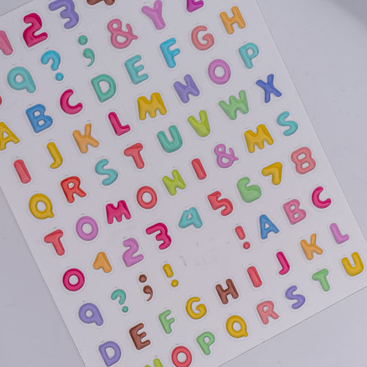 Sheet of colorful alphabet and number stickers on a white background