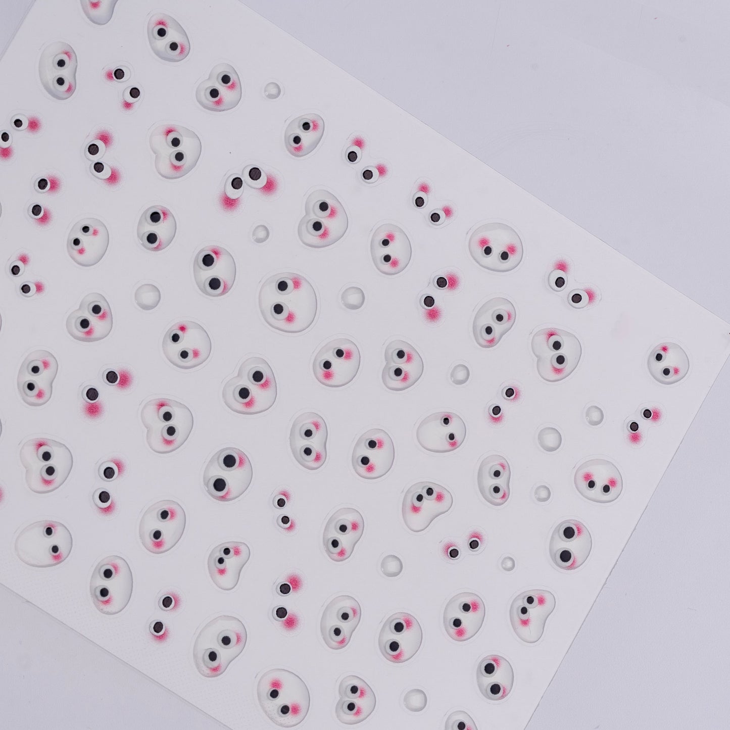 Sheet of small round stickers with cartoonish faces on a white background