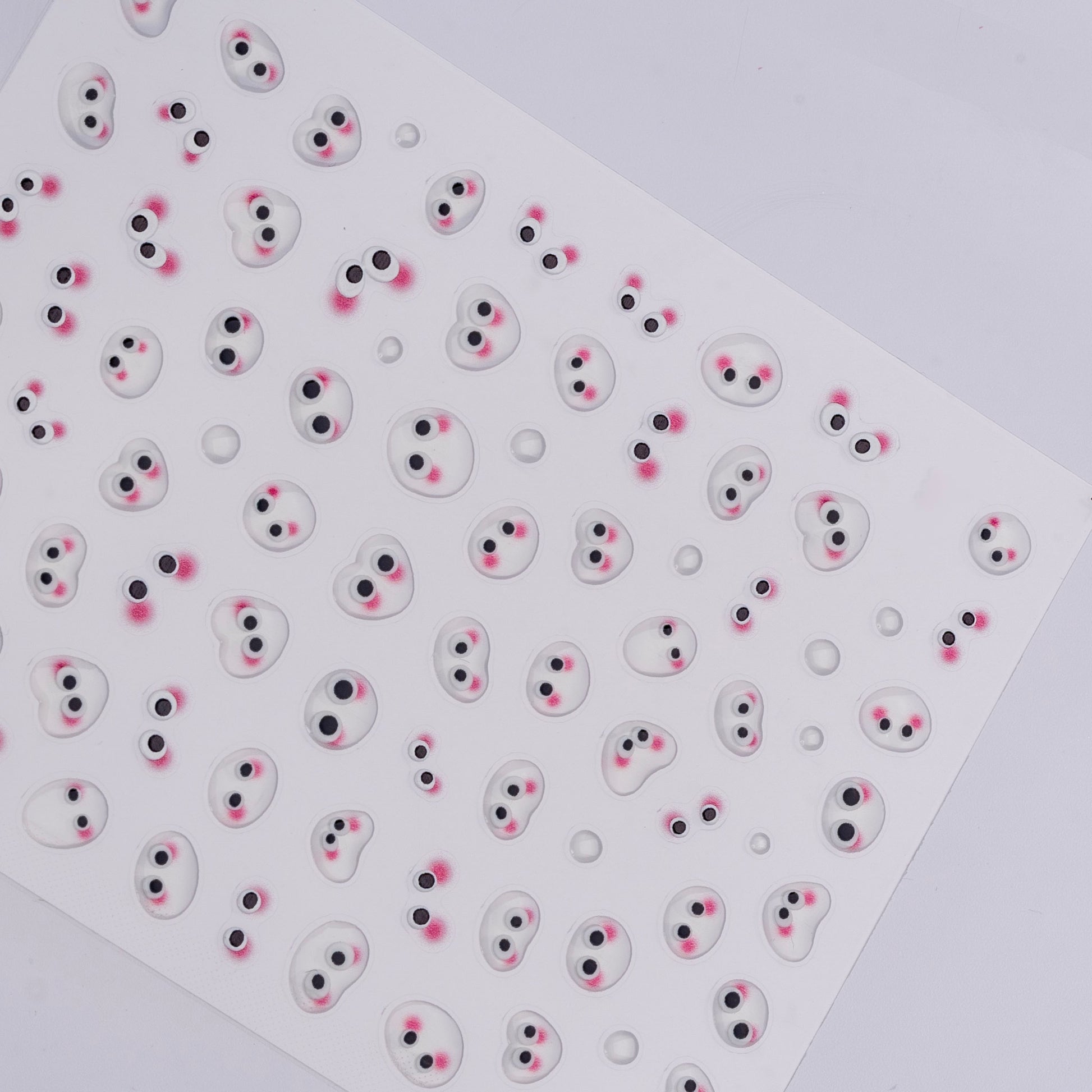 Sheet of small round stickers with cartoonish faces on a white background