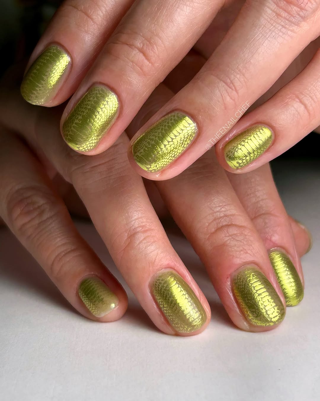Manicured hands with detailed chrome nail art