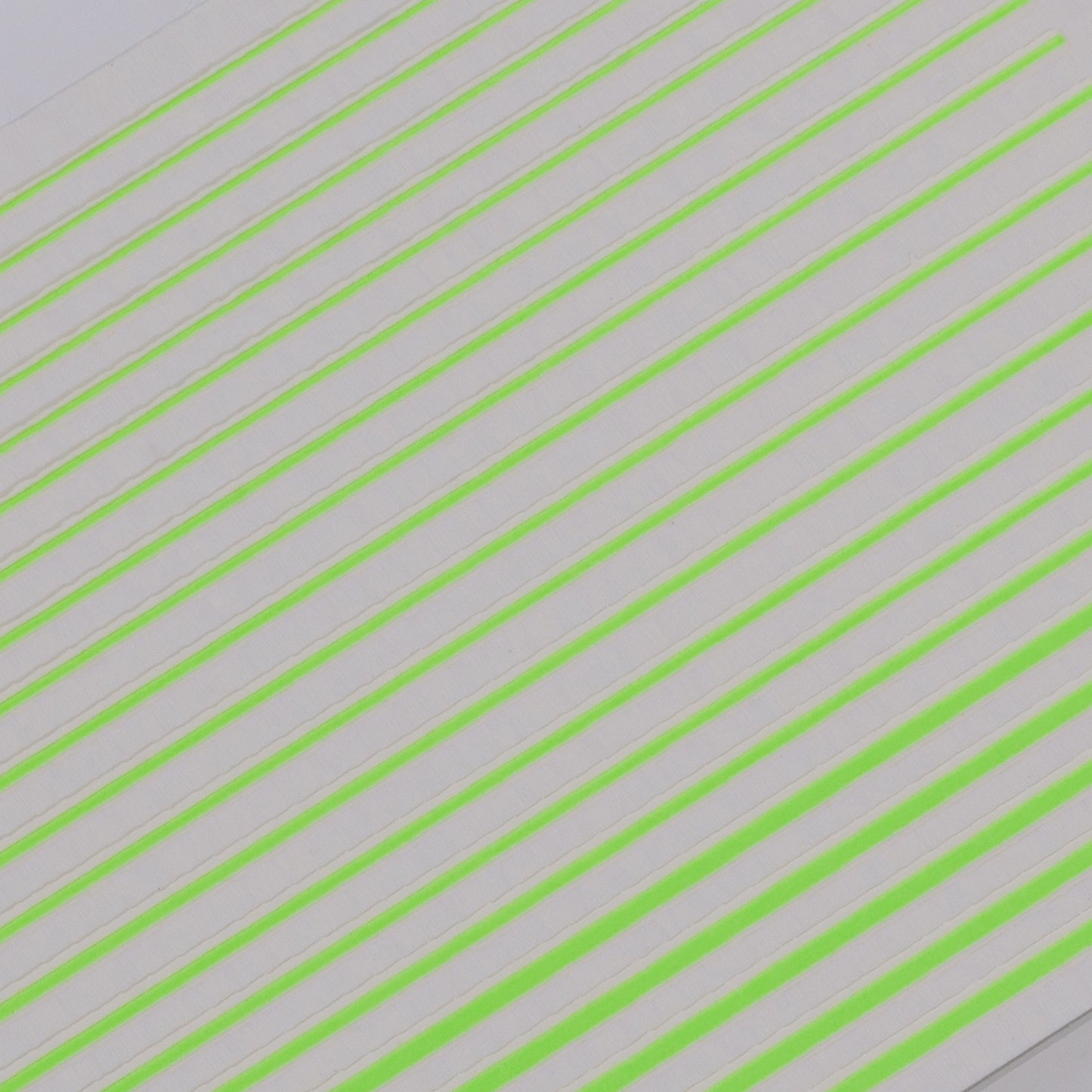 Close-up view of neon line nail stickers on white background.