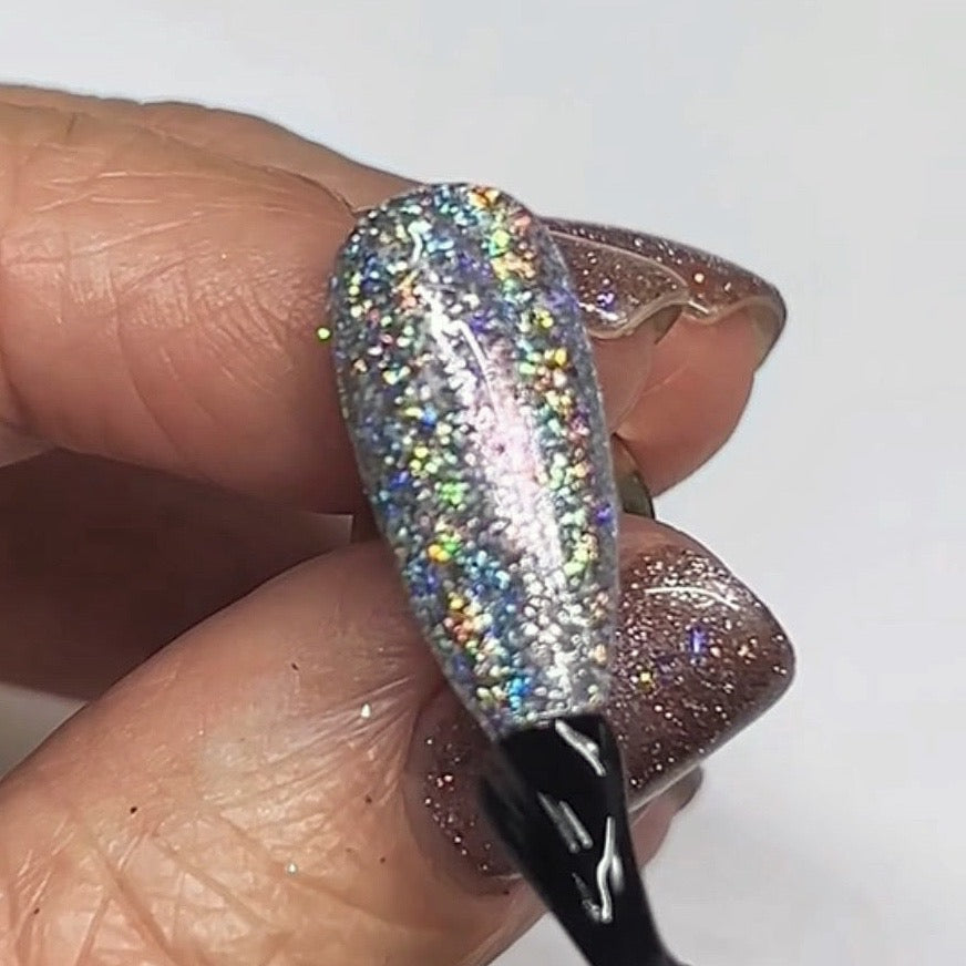 Hand holding nail tip with silver glitter design 