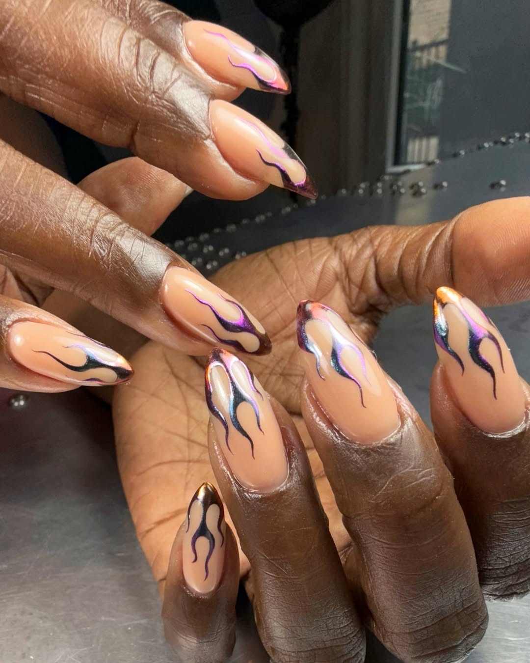 Manicured hands with metallic flame design 