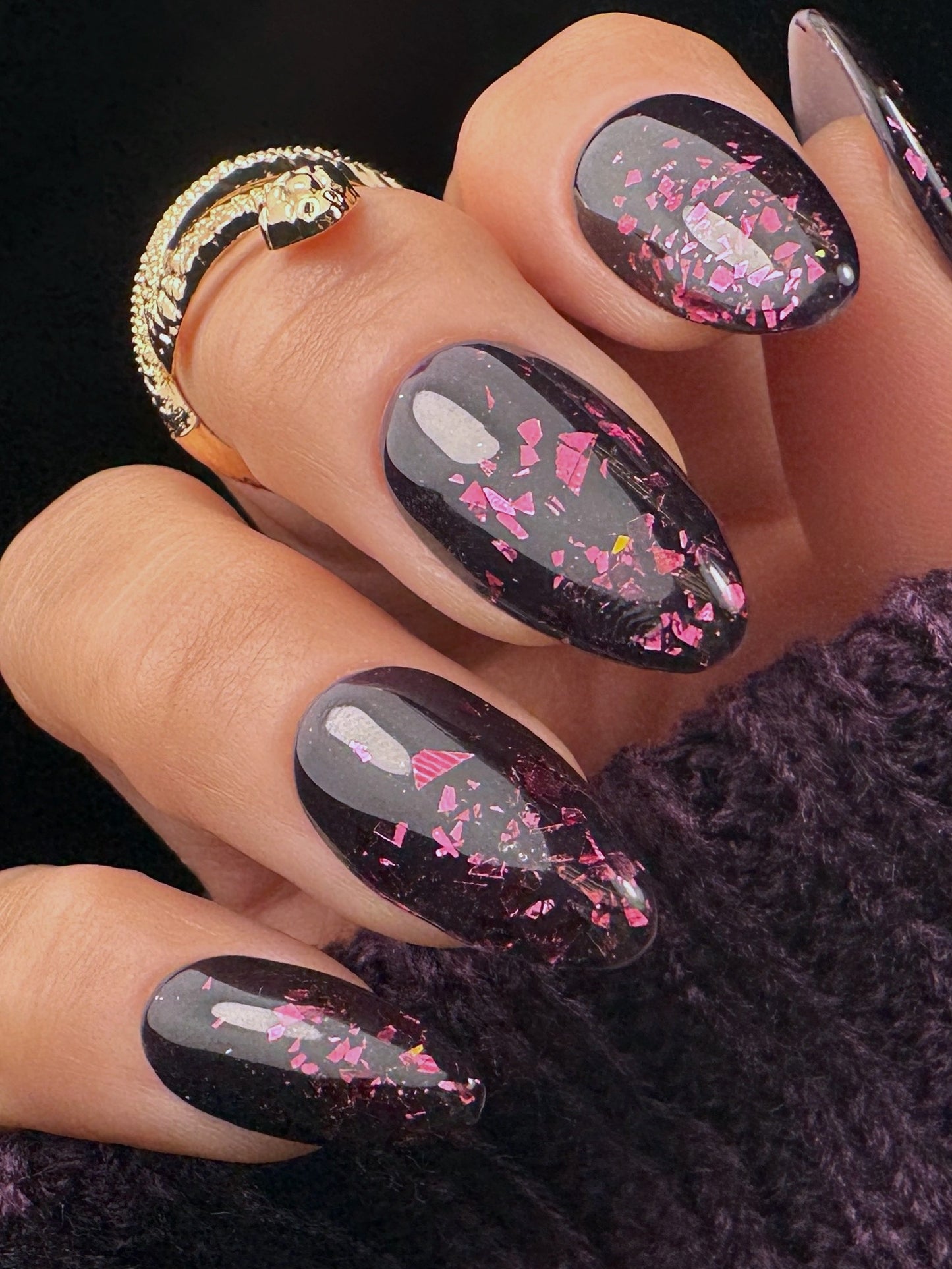 Nail art with burgundy glitter on a dark background