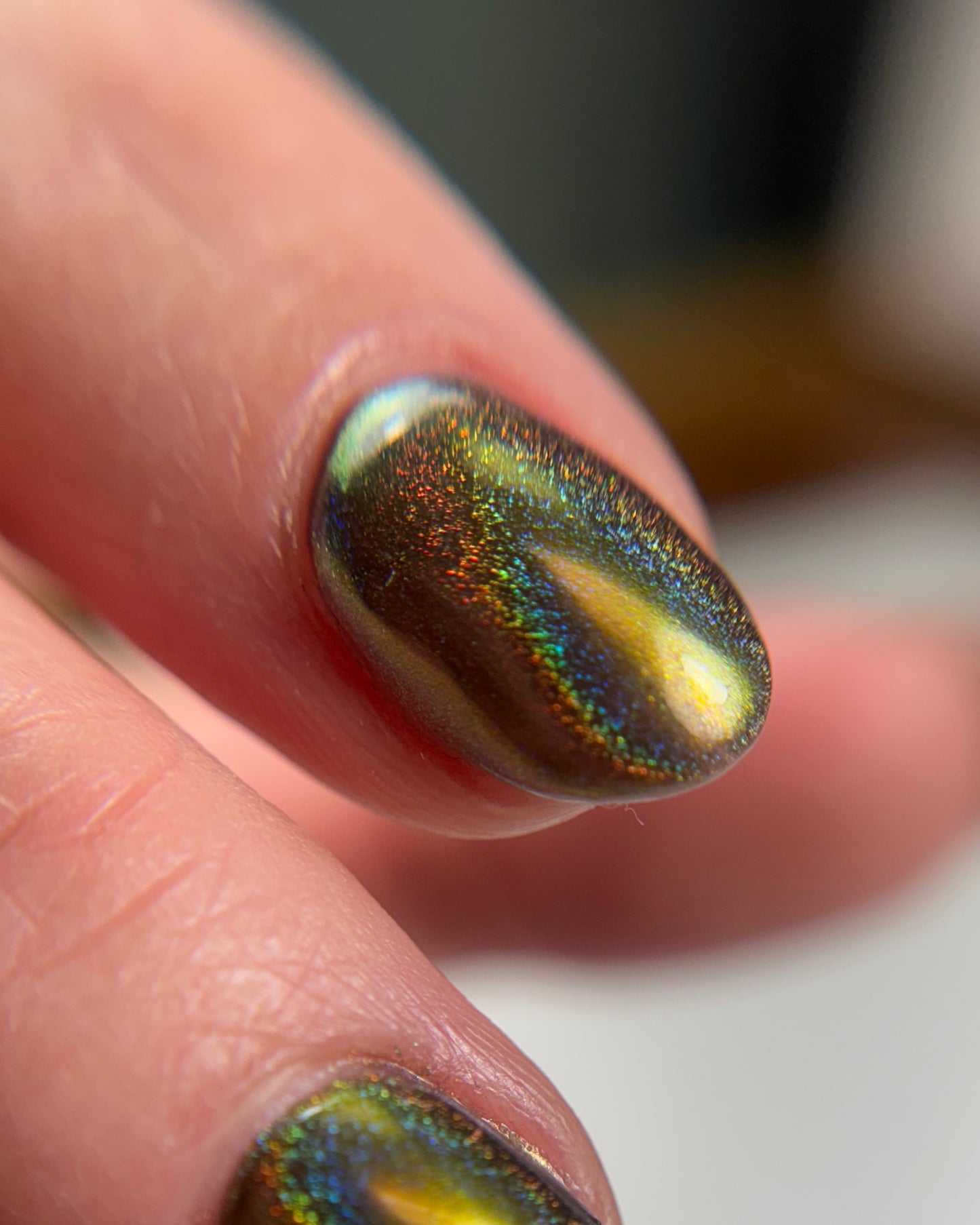 Close up of iridescent nail design on blurred background