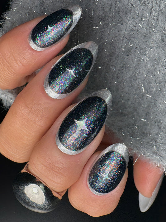 Nails with black and silver glitter design on a dark background