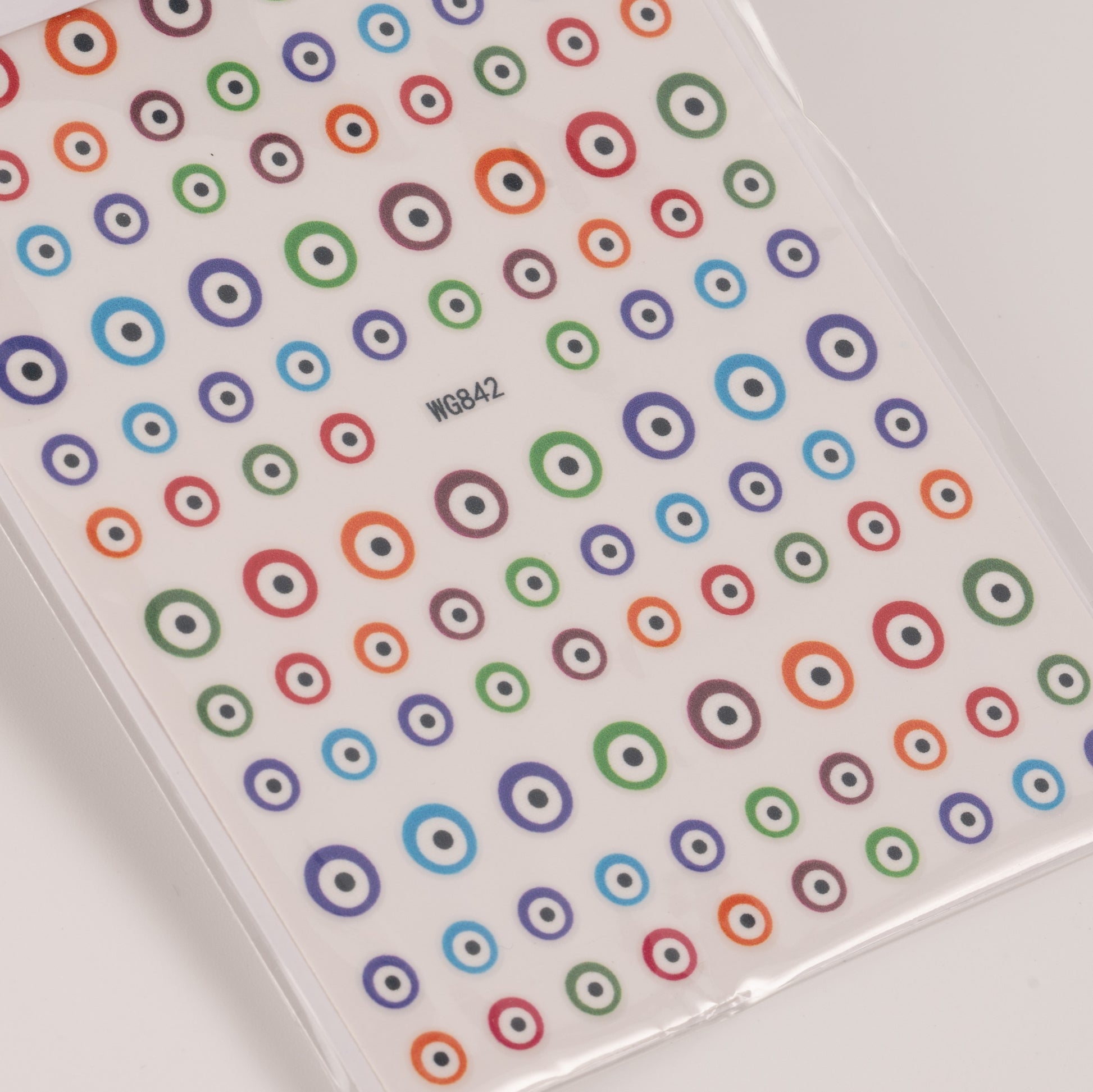 Nail decal sheet with colorful eye design on light background.