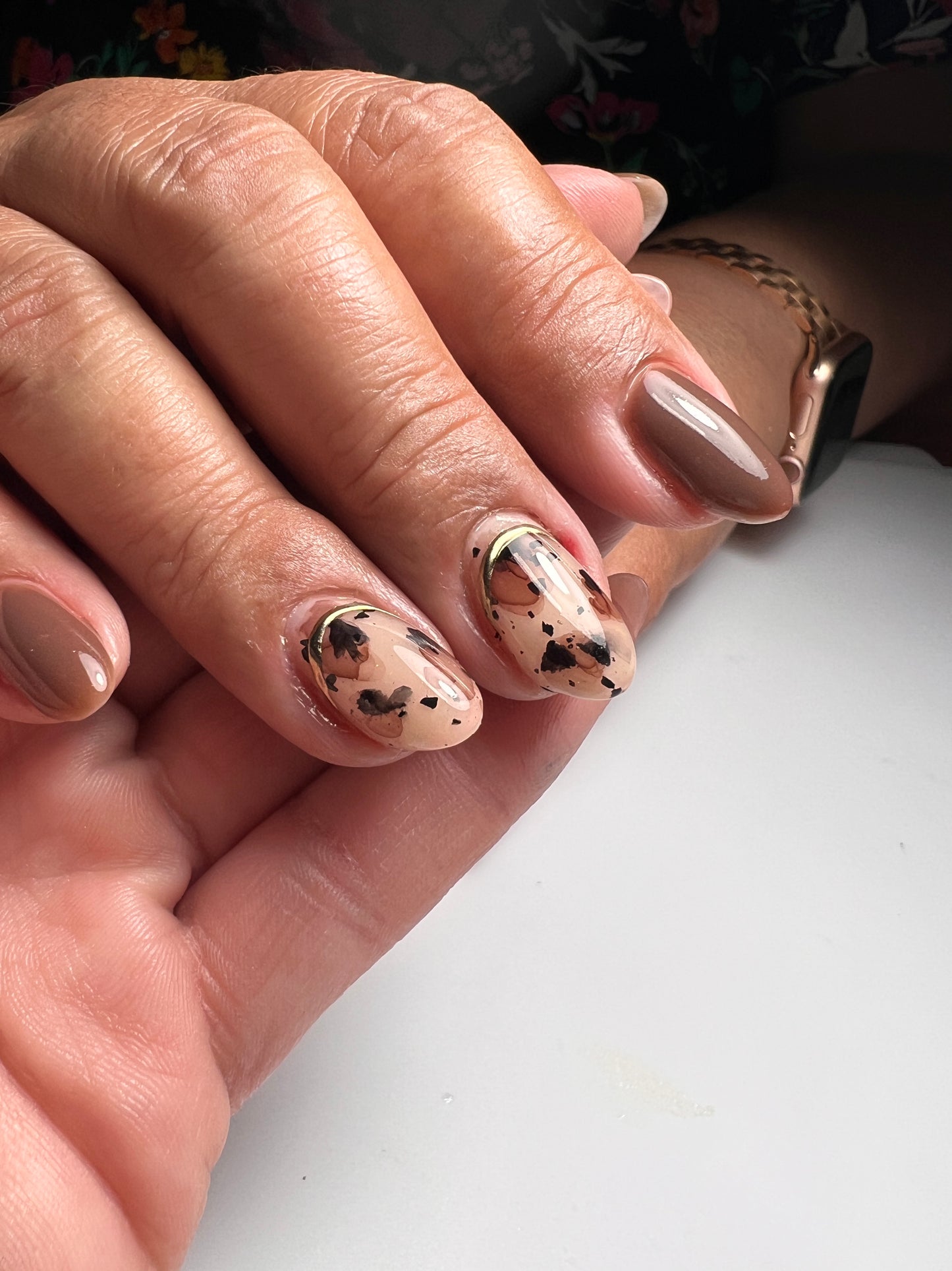 Close up view of manicured hand with nail art on light background.