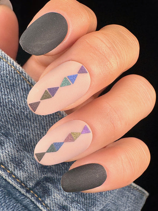 Nails with geometric pattern and black polish on a denim background
