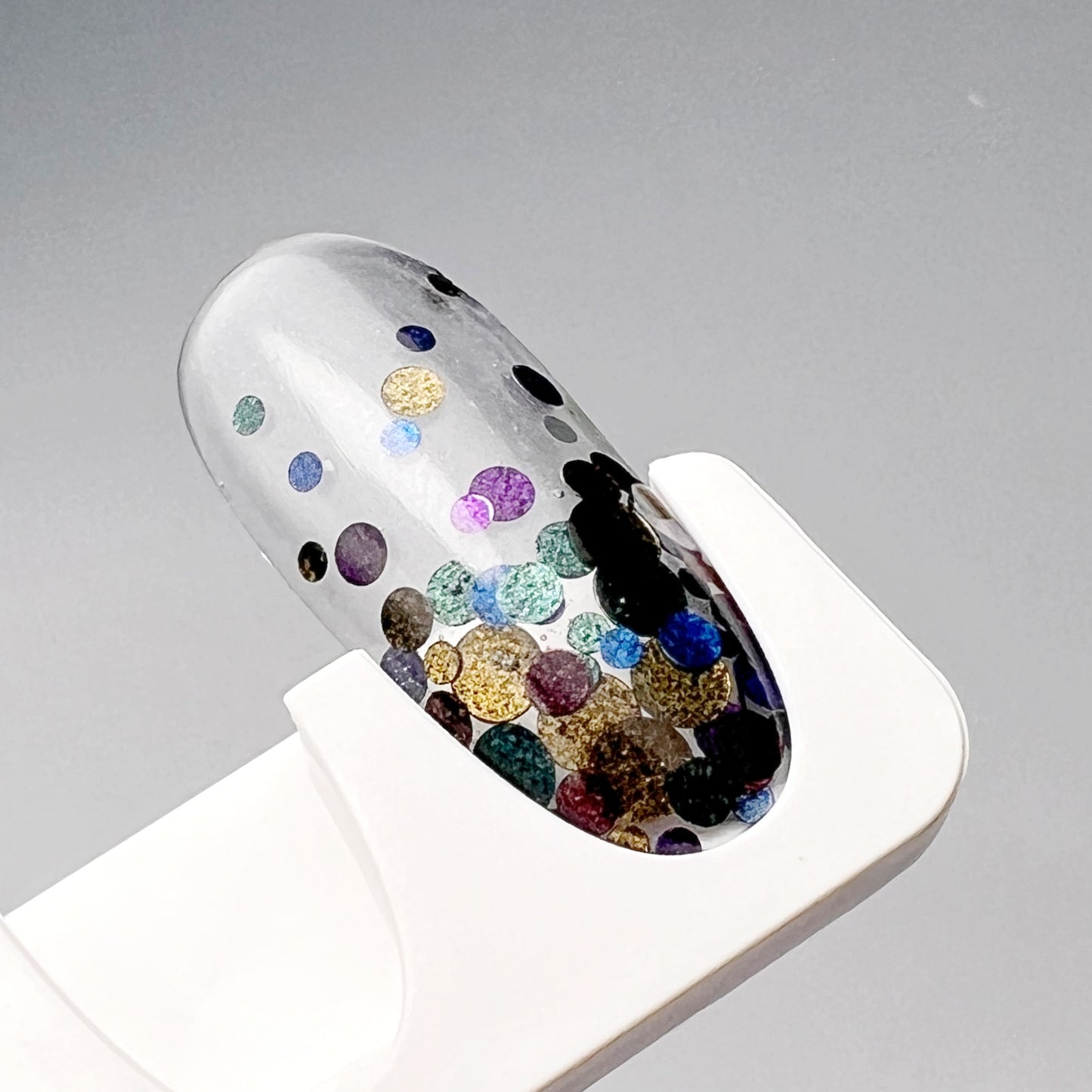Decorated nail tip on white holder. 