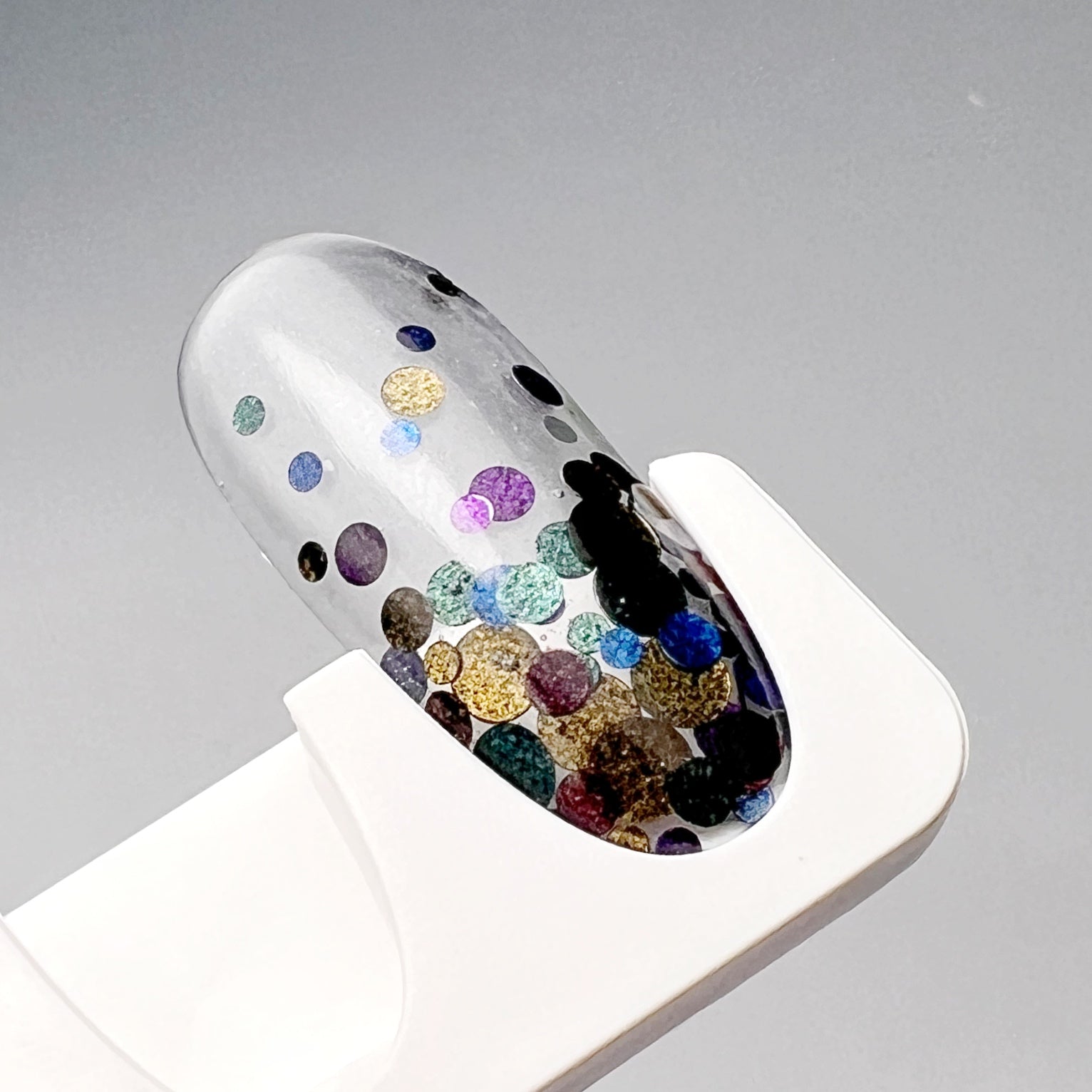 Decorated nail tip on white holder. 