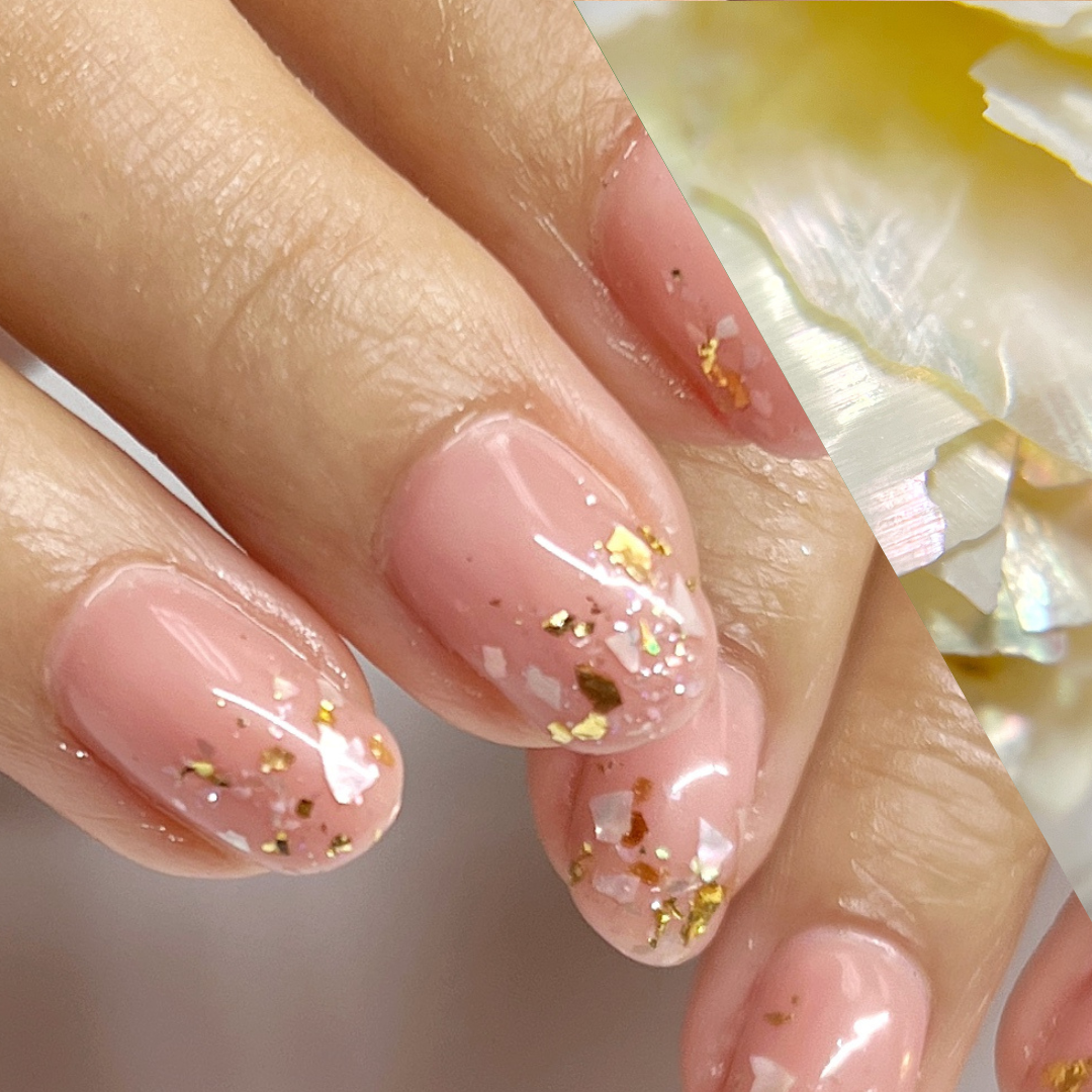 posed hands with nail art anda diagonal swatch of shell closeup. 
