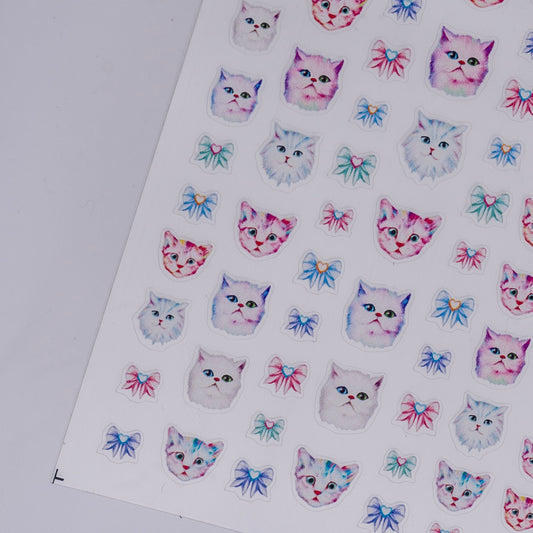 Sheet of stickers with cat faces and bows on a white background