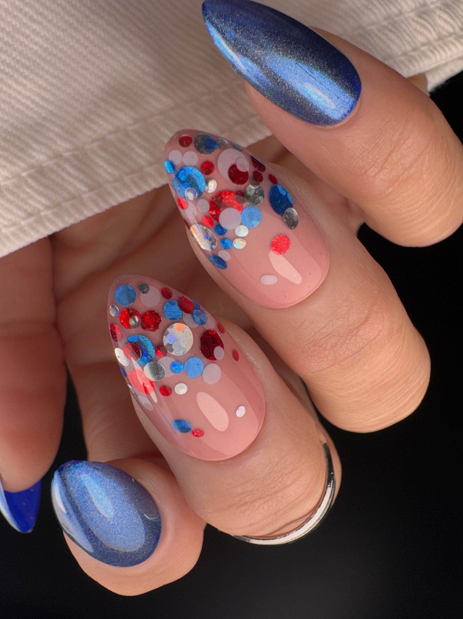 Close-up of a hand with red, white, blue and silver glitter nail art