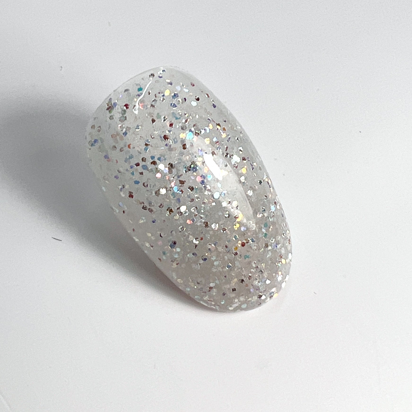 Glitter nail tip swatch on white background.