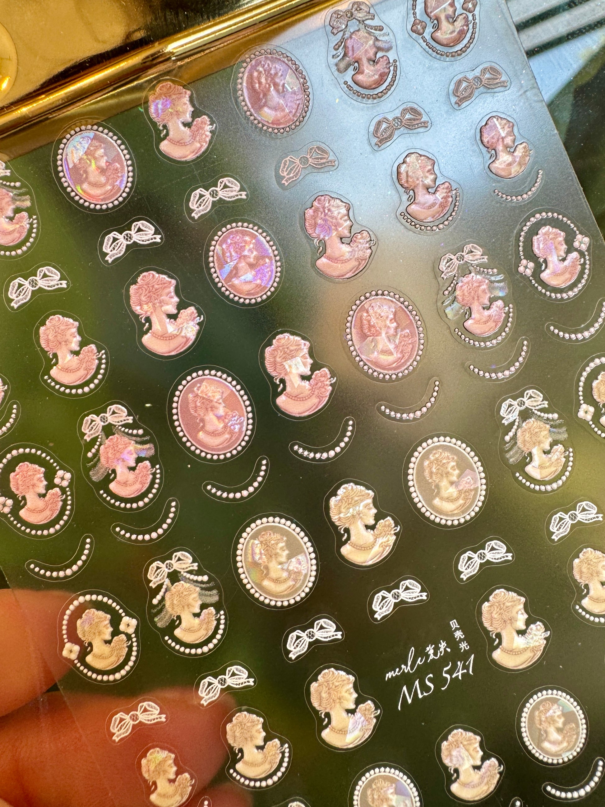 Sheet of decorative stickers with vintage-style illustrations on a reflective surface.