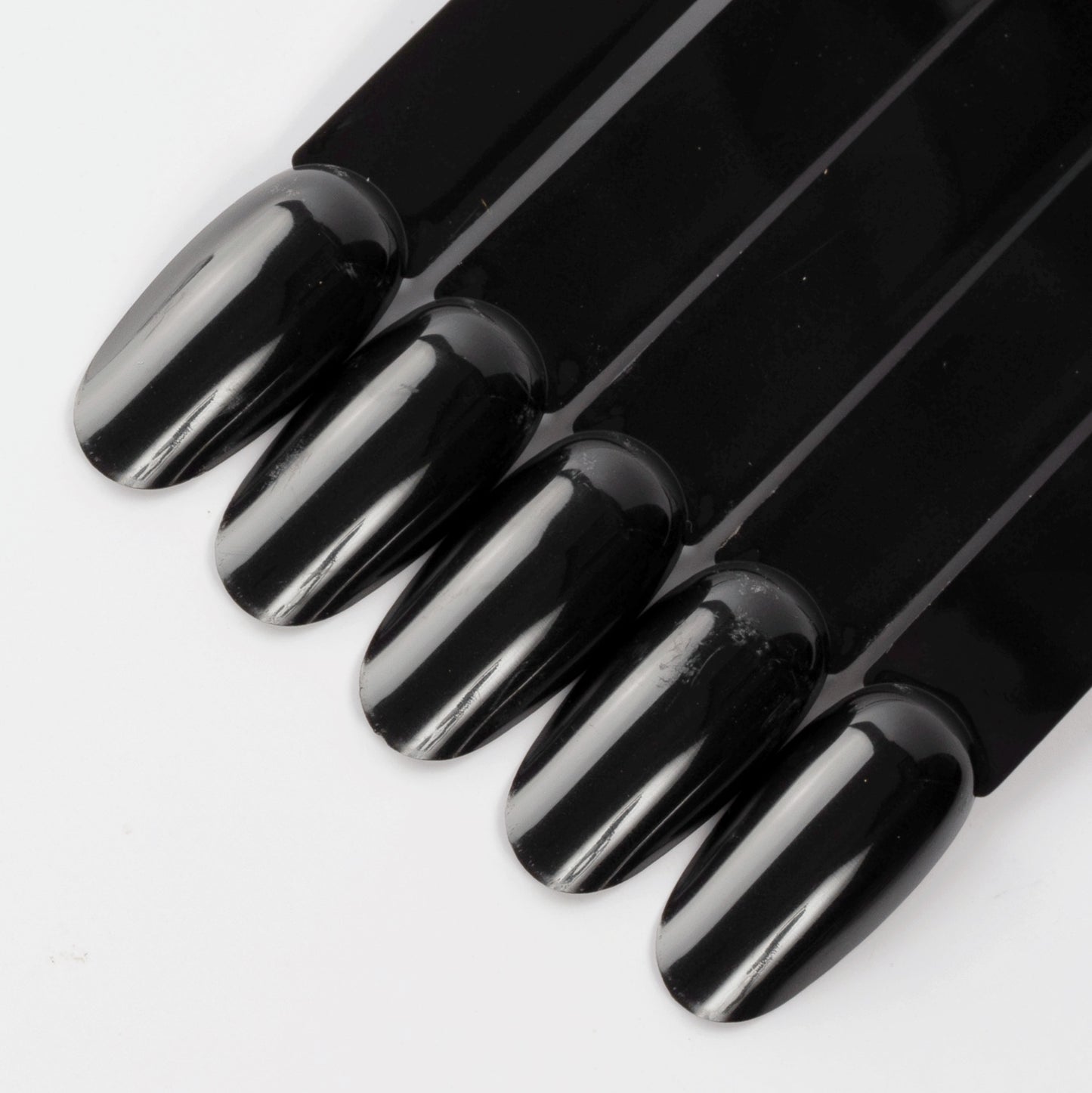 Black oval nail swatch sticks on white background.