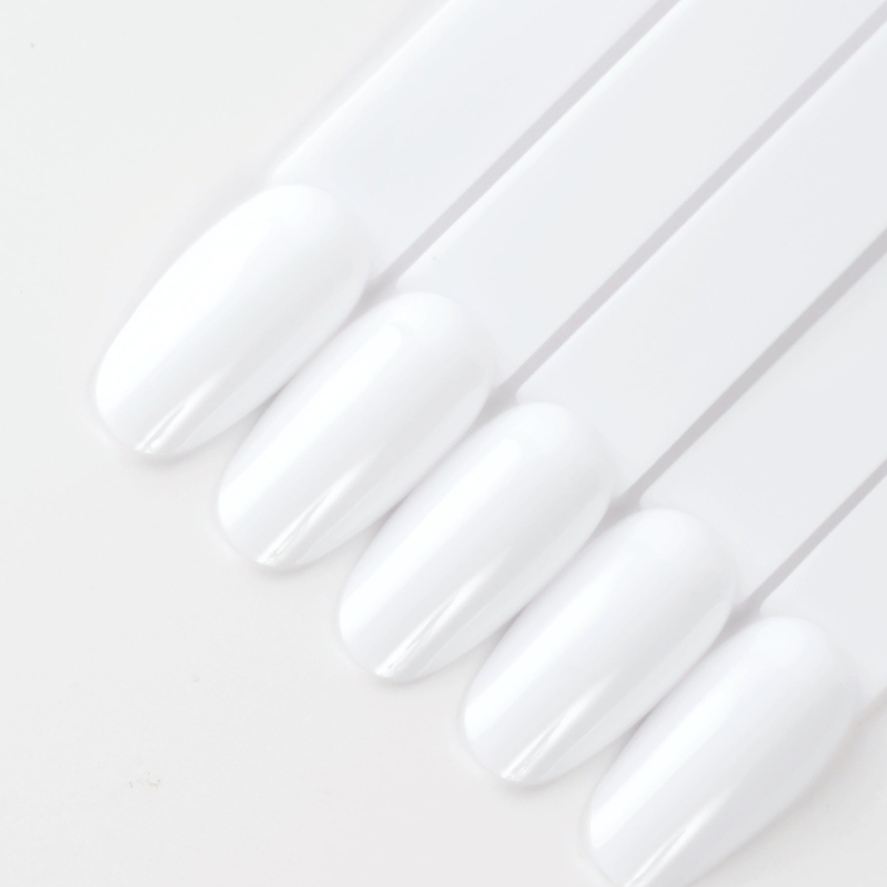 White oval nail swatch sticks on white background. 