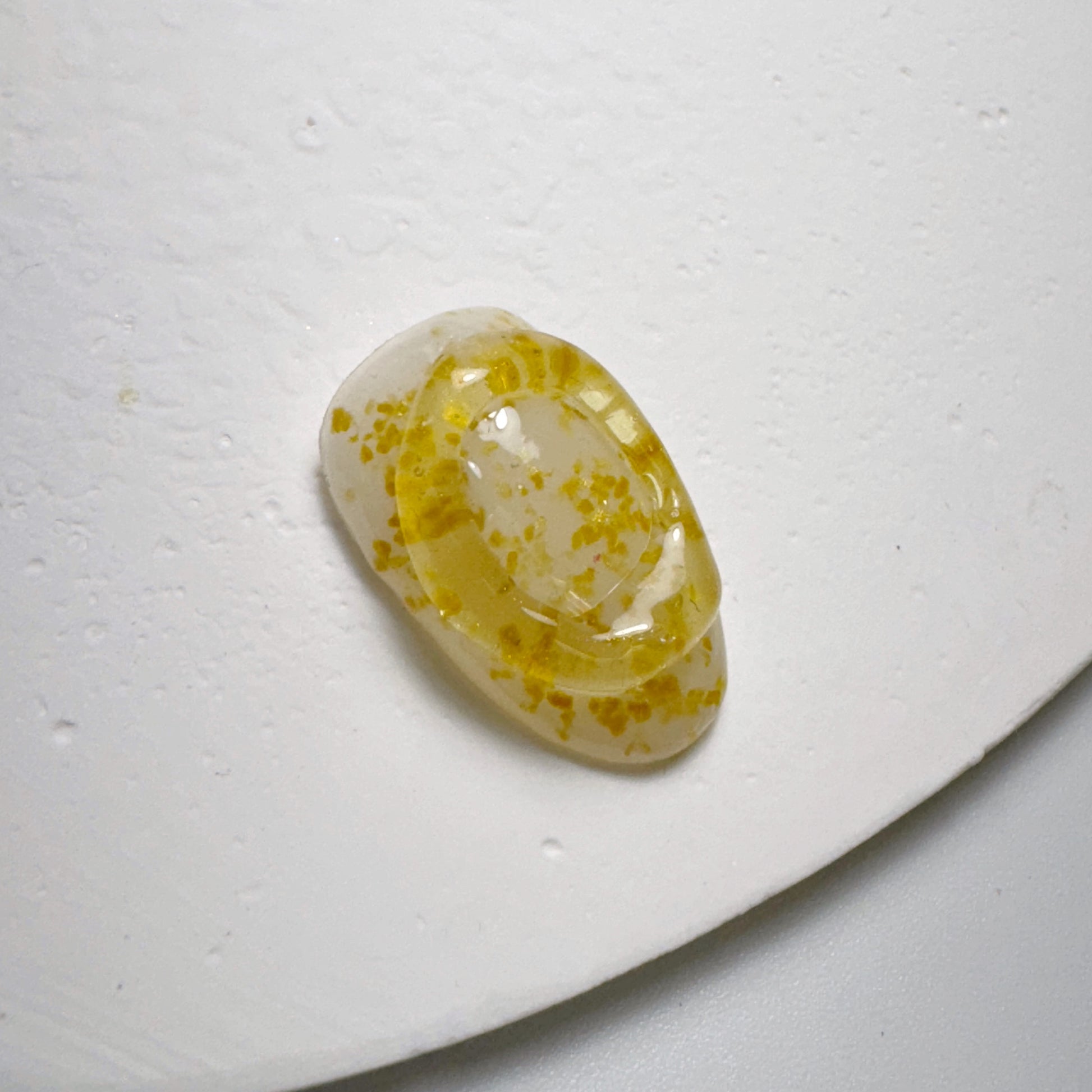 Decorated nail tip on textured white surface.