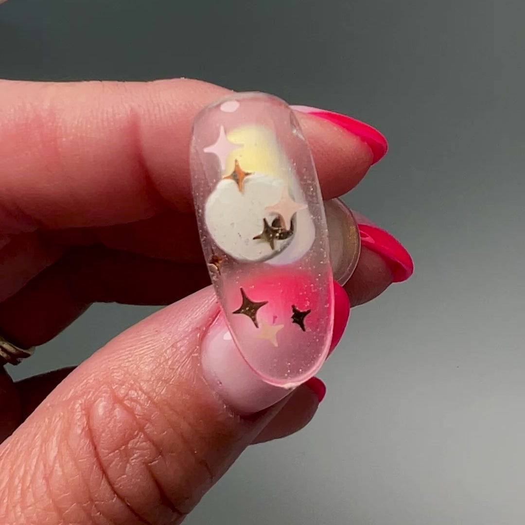 Video of hand holding decorated nail tip. 