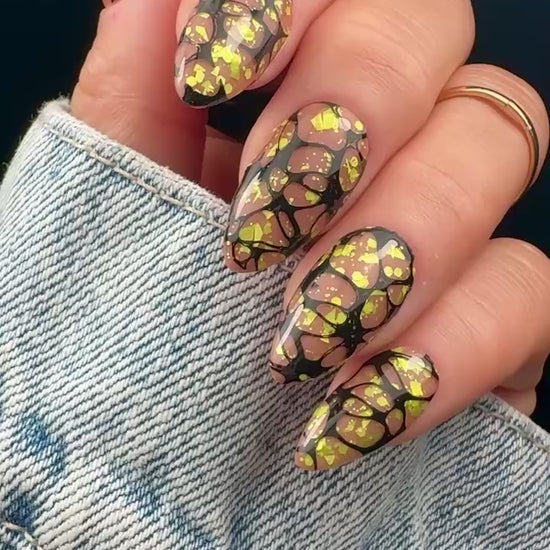 Video of nails with a graphic web design in yellow and black on a neutral background