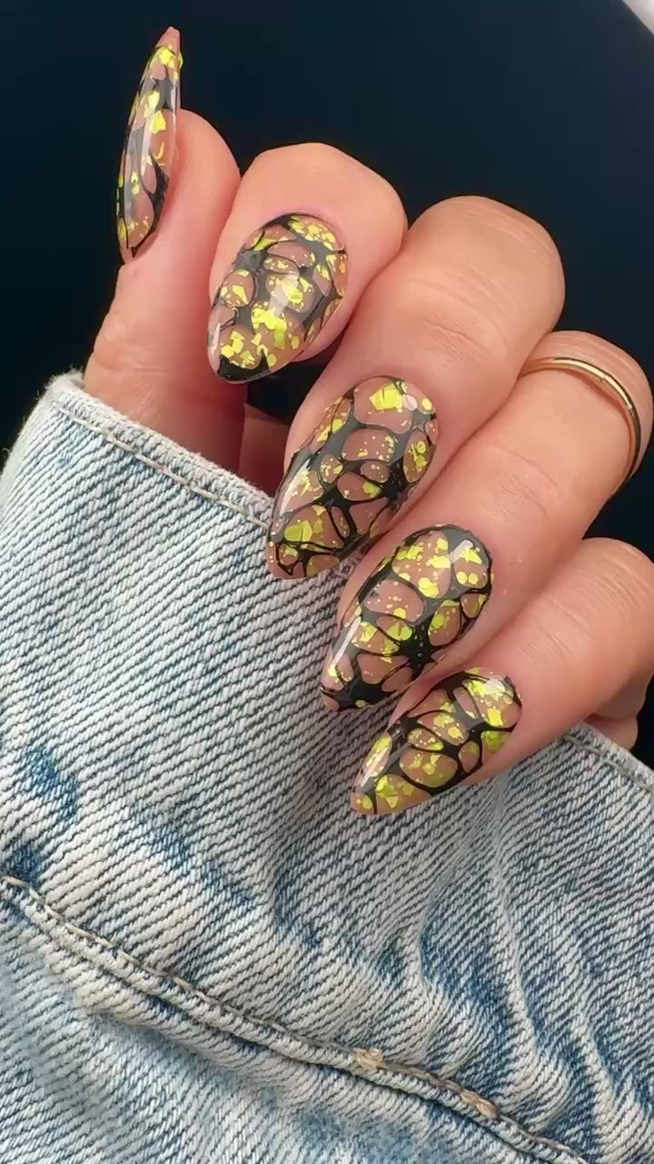 Video of nails with a graphic web design in yellow and black on a neutral background