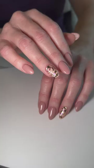 Video of a nude manicure by nail artist Melissa Robillard featuring Vacation Nail Shop Rose & Champagne Spots Glitter, with scattered metallic rose and champagne glitter accents on select nails.