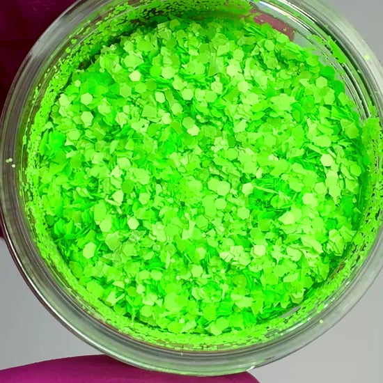 Video of hand in pink glove holding clear jar with textured glitter.