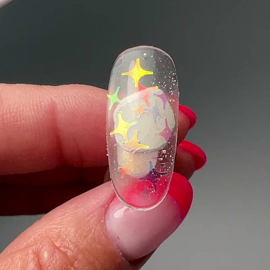 Video of hand holding a nail tip on gray background. 