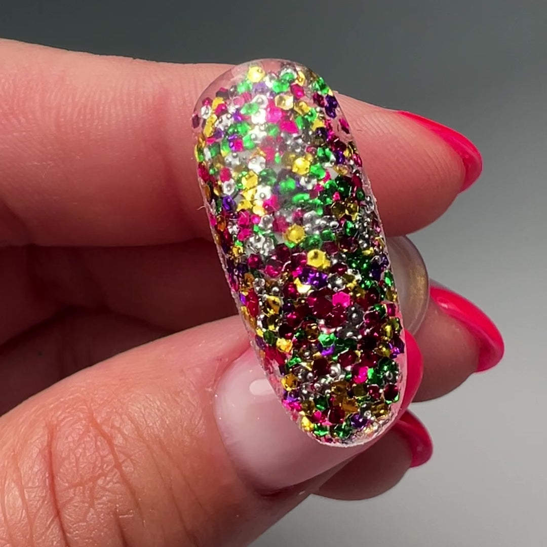 Video of hand holding decorated nail tip. 