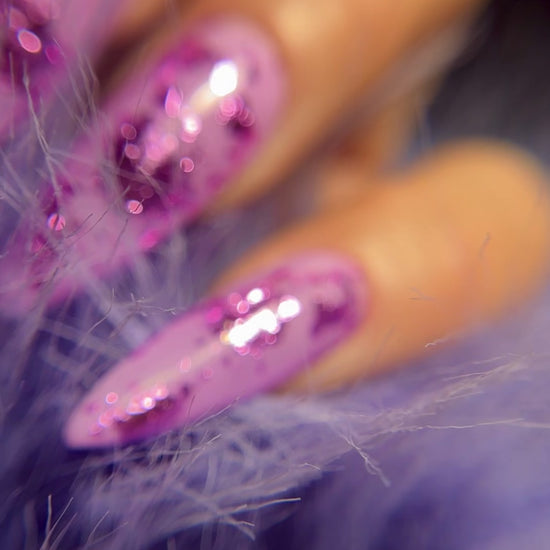 Close up of manicured hand with glittery nail art on blurred background